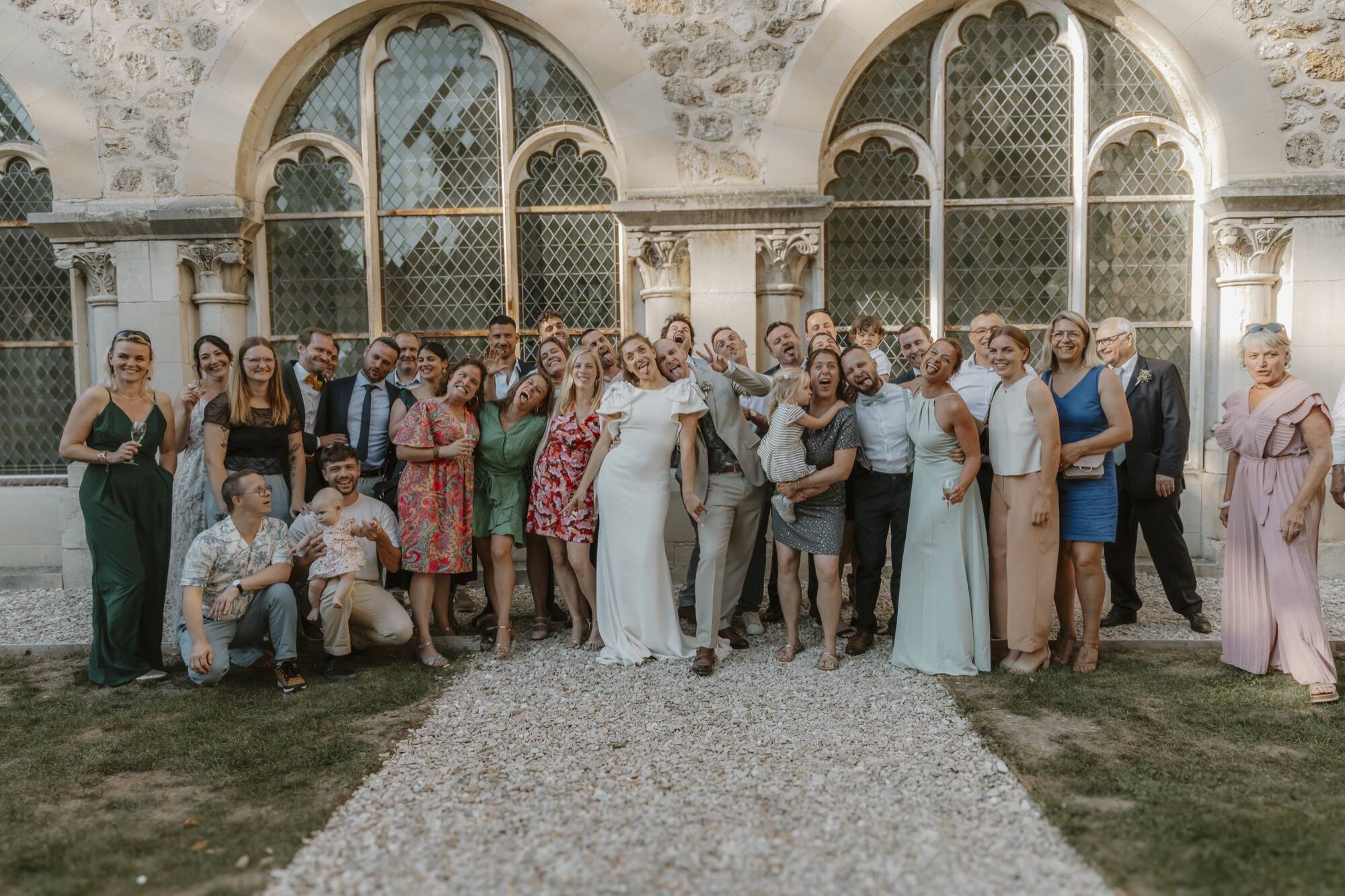Photo de groupe des invités devant les grandes verrières du cloître du Prieuré de Binson