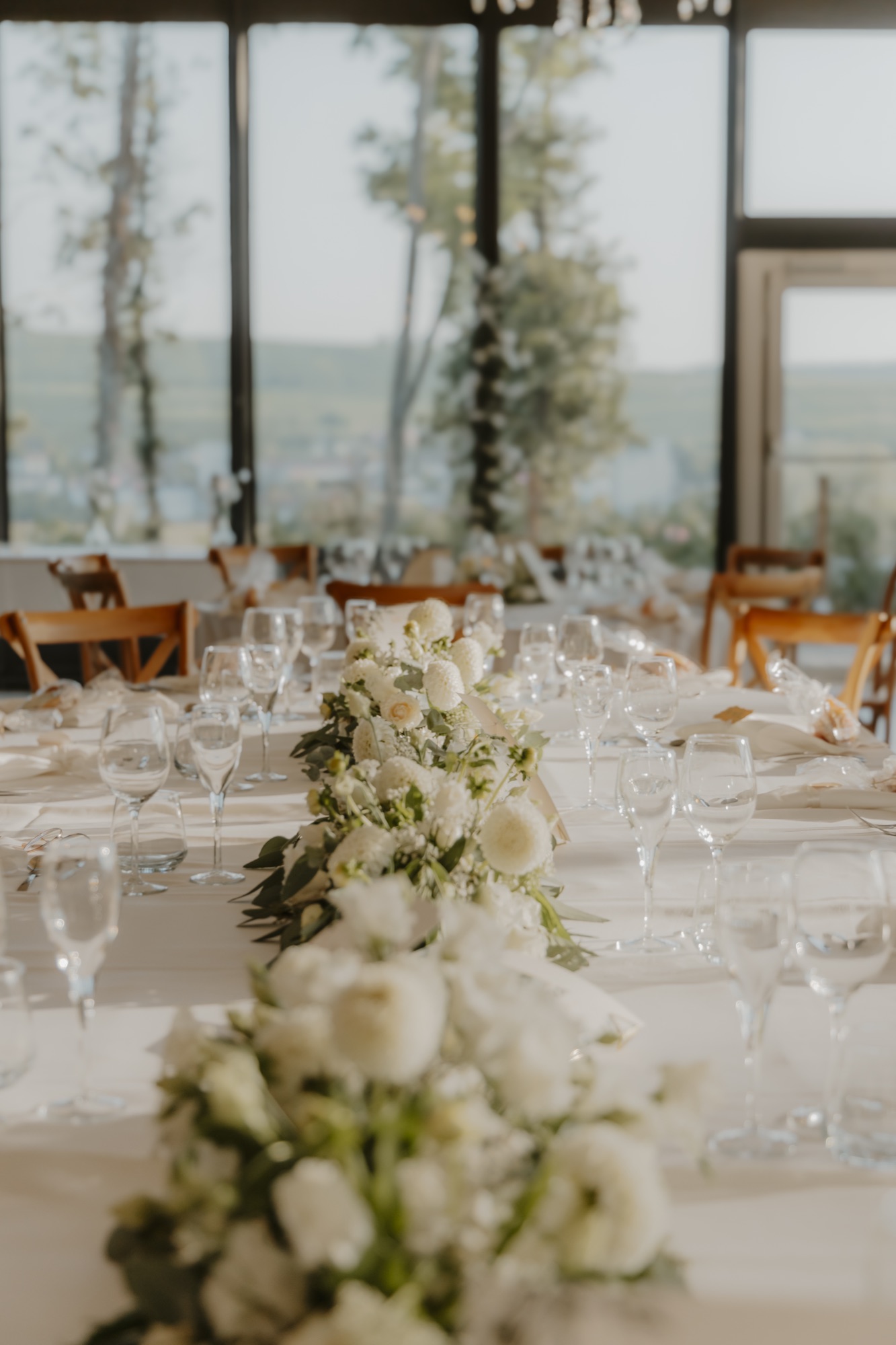 Table du dîner dans l’orangerie, chemin de fleurs blanches et vue sur la vallée
