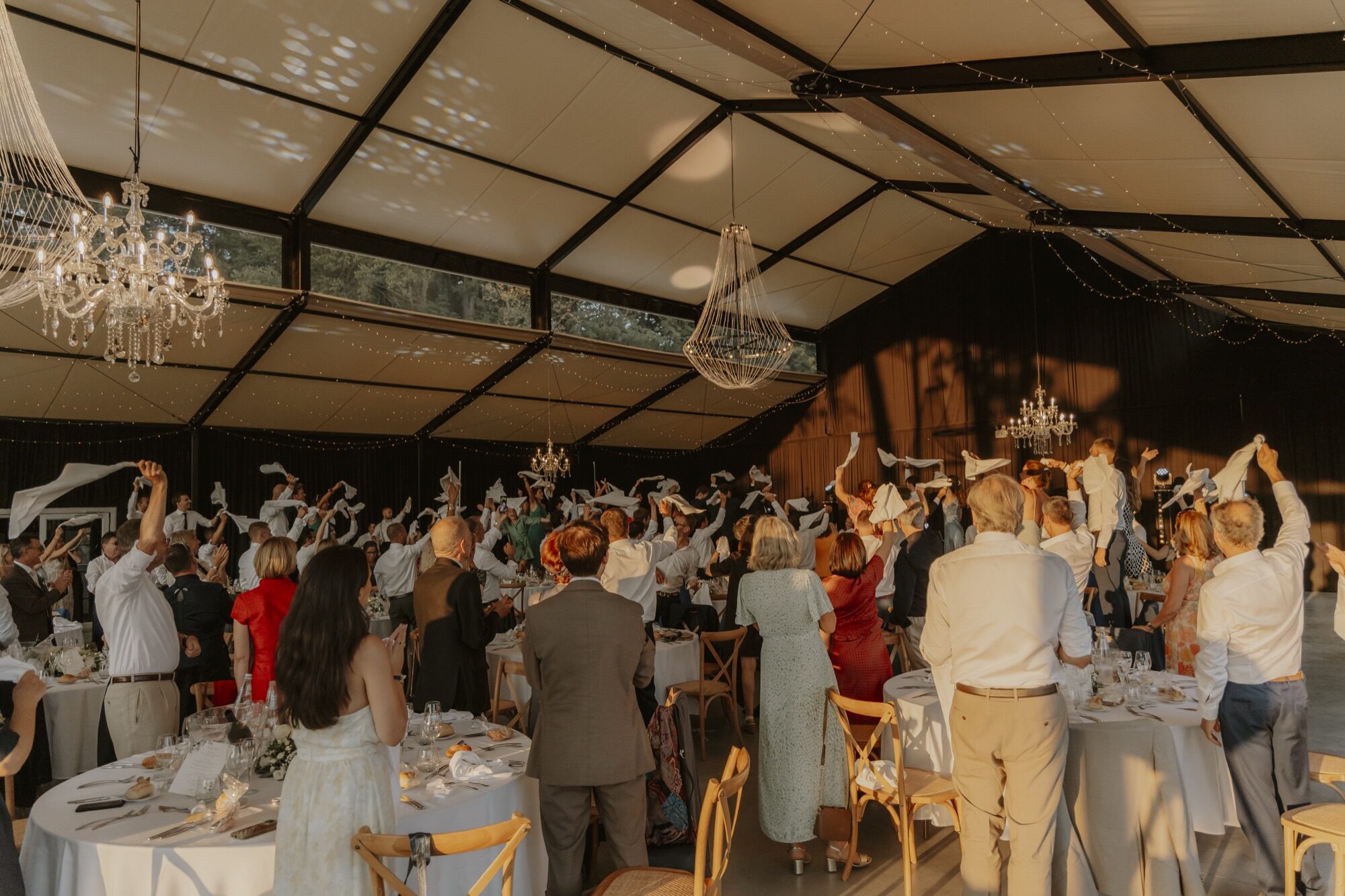 Les invités font tourner leurs serviettes sous les lustres de l’orangerie