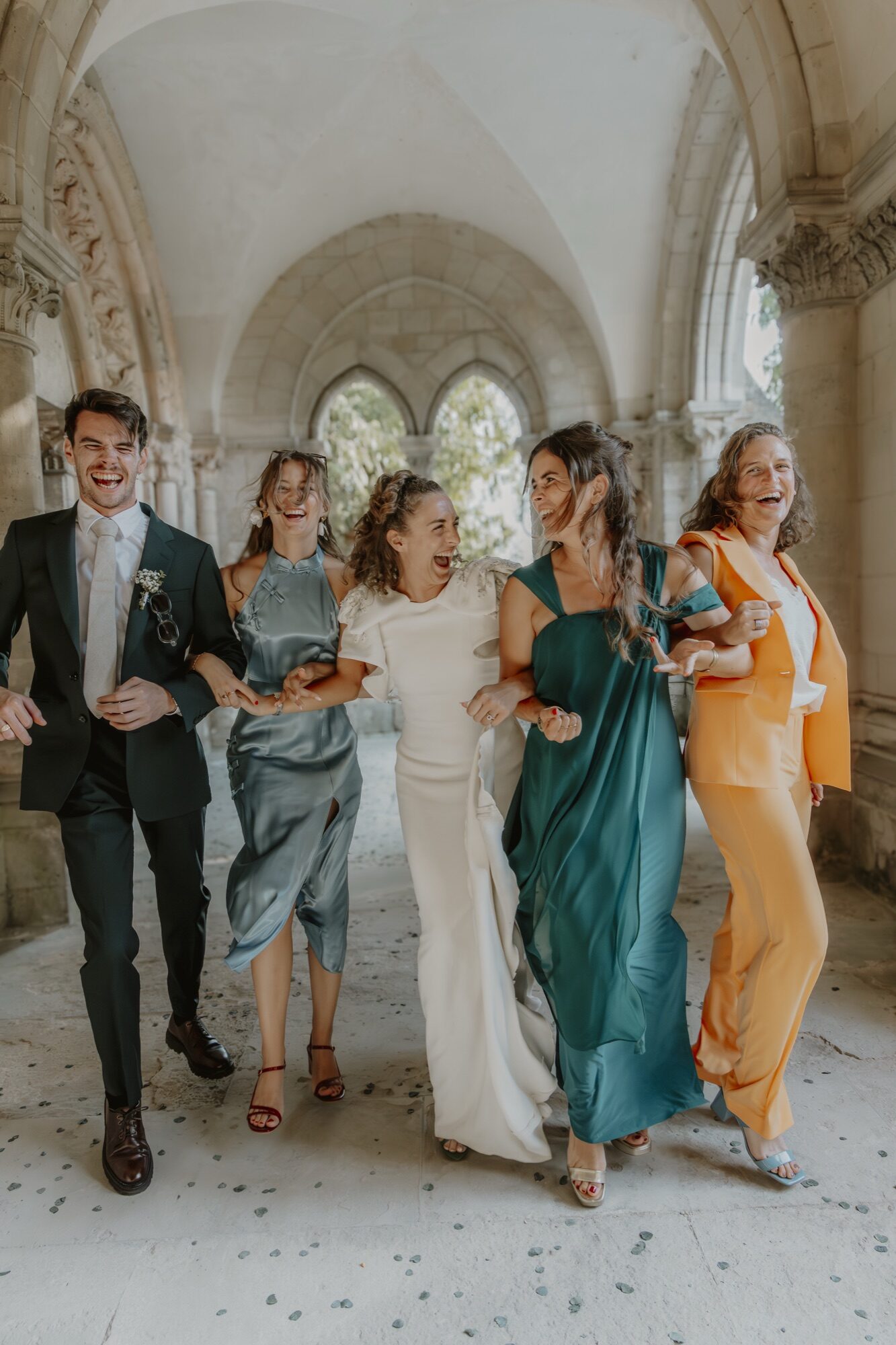 Les témoins de Mathilde et Henri, bras dessus bras dessous et éclats de rire dans le cloître — reportage de mariage