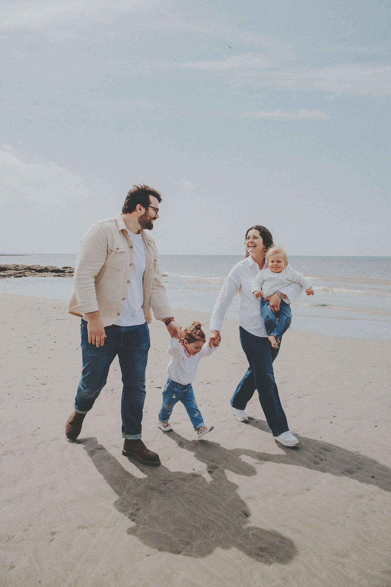 Famille marchant main dans la main sur la plage — photographe famille Côte d’Opale