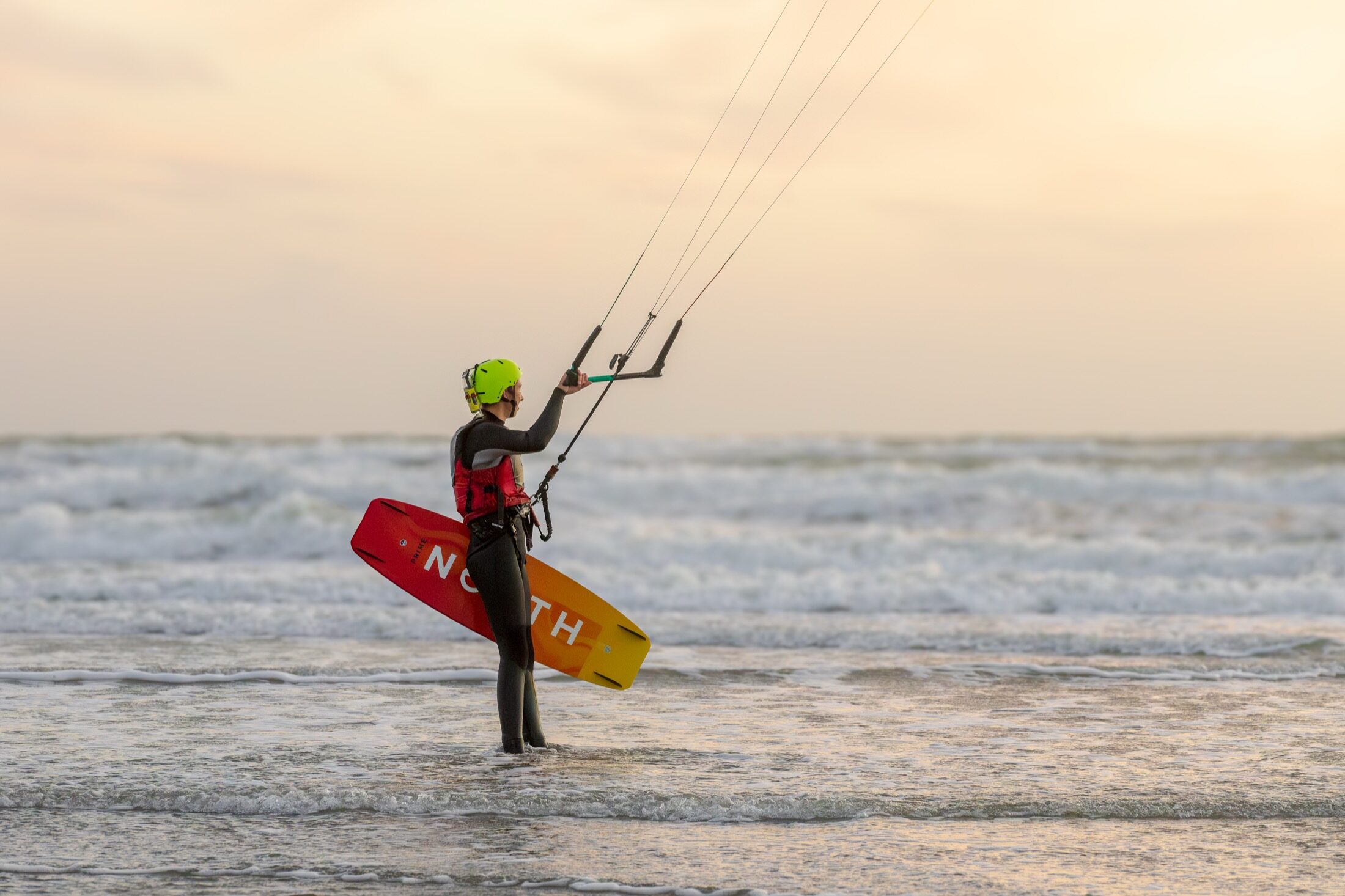 Kitesurfeur sortant de l’eau, planche rouge à la main — photographe de kitesurf à Wimereux
