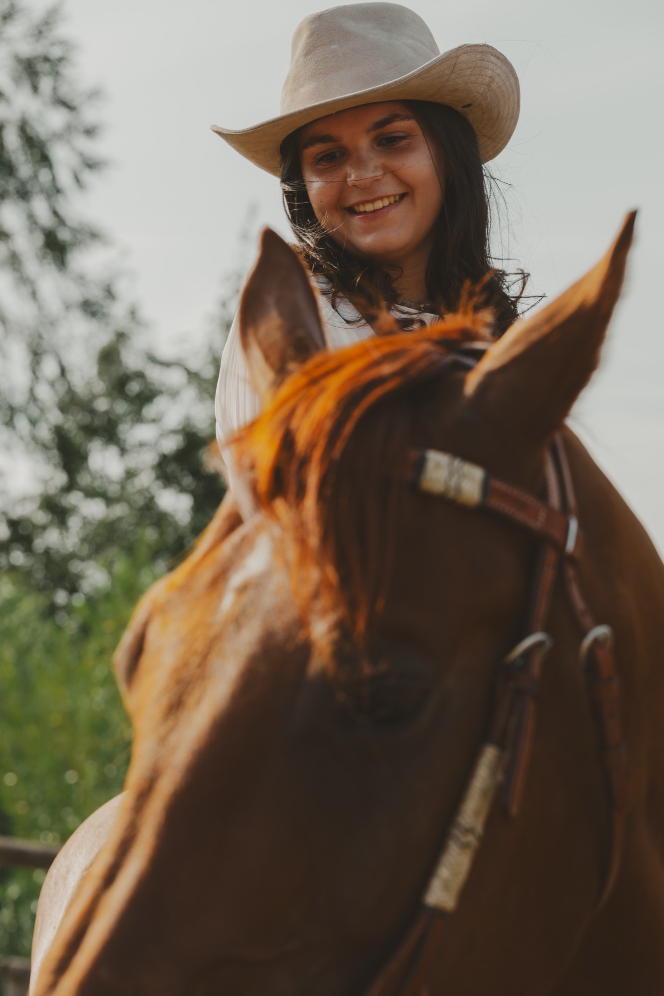 Louise Virgata souriante, en selle derrière l’encolure de son cheval — séance photo équestre