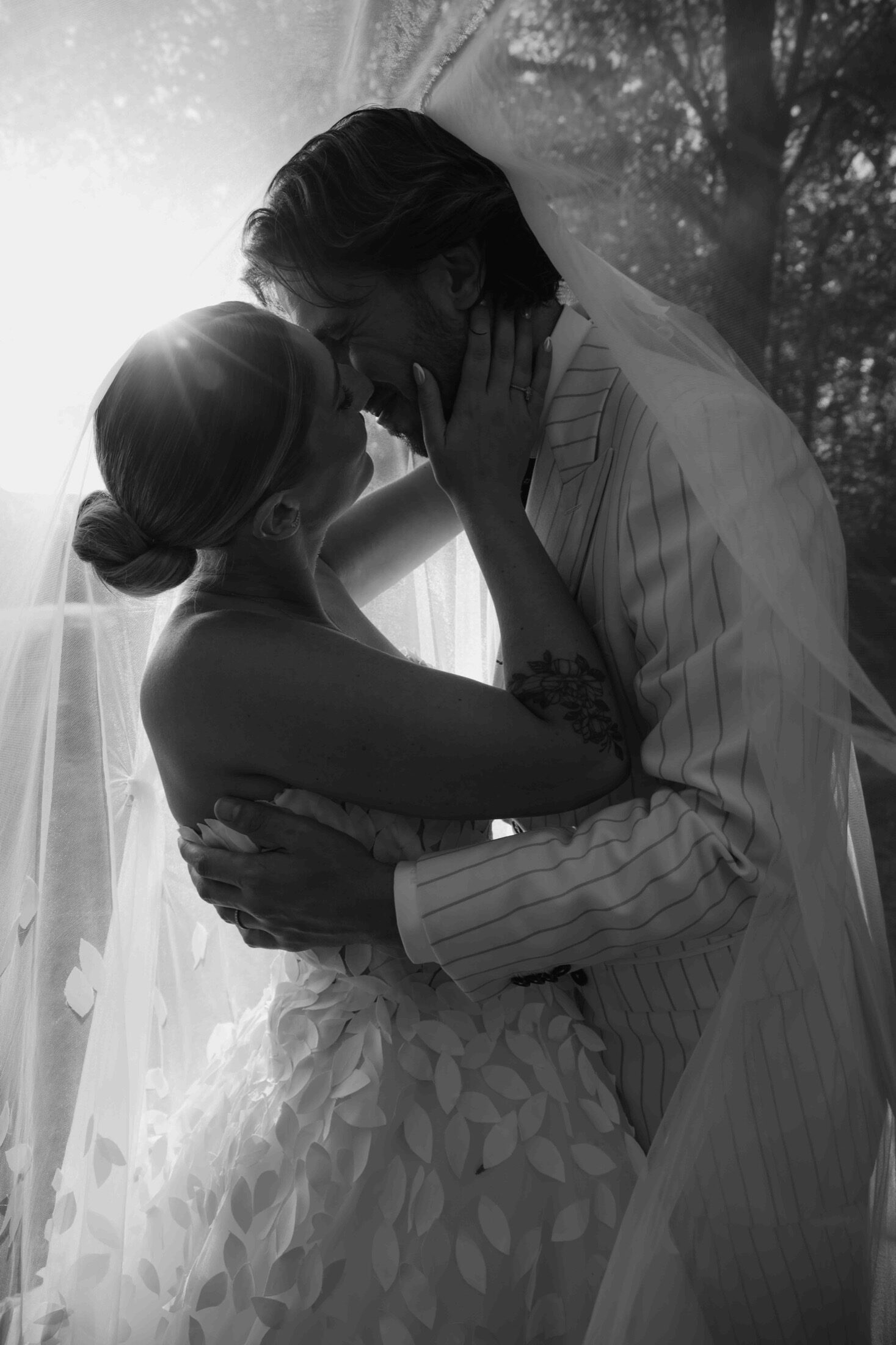 Les mariés s’embrassent sous le voile, en noir et blanc — photo mariage Côte d’Opale