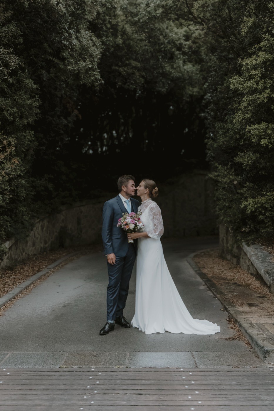 Les mariés main dans la main dans une allée boisée — photographe de mariage de Boulogne-sur-Mer à Calais