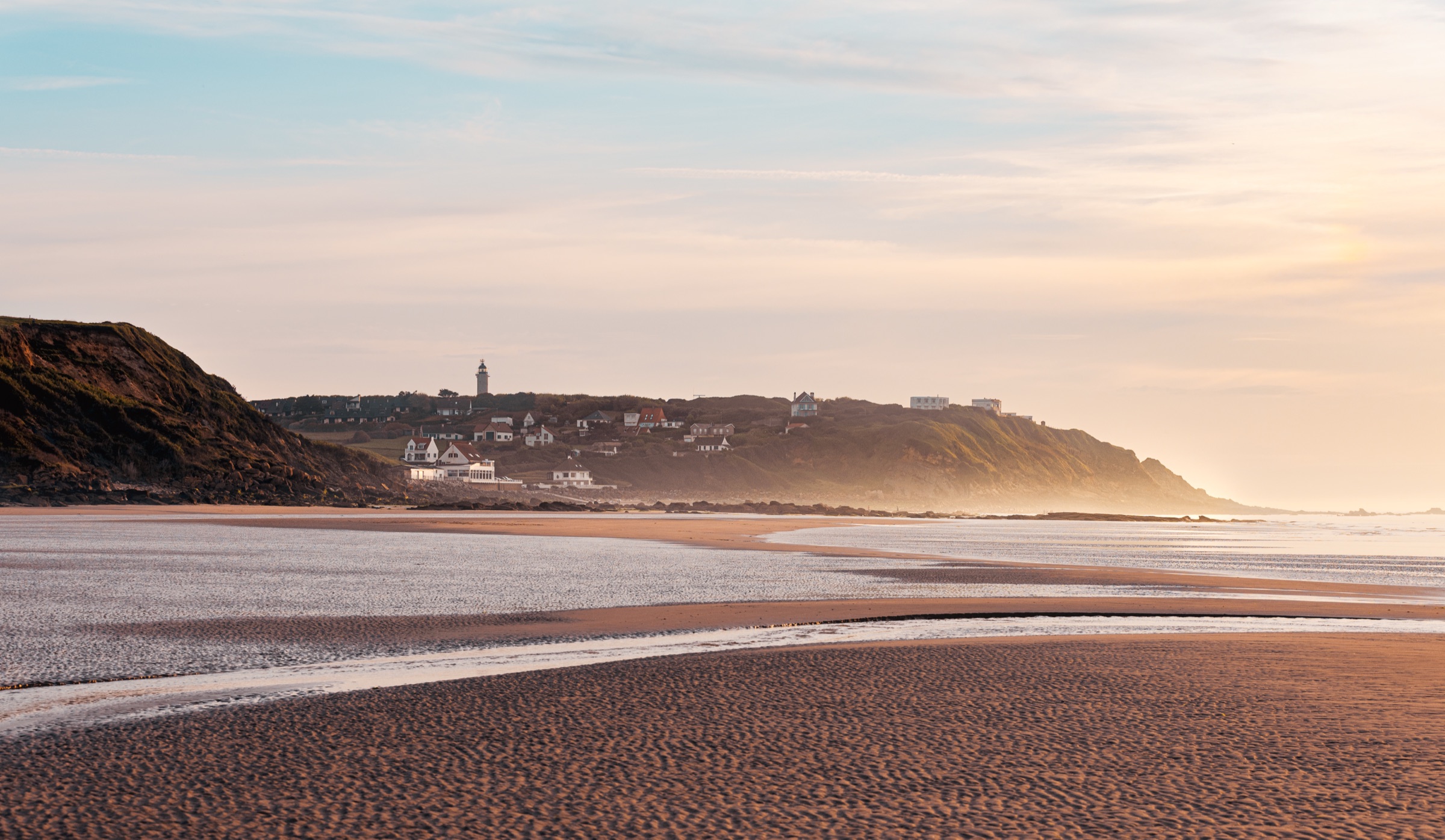 Plage de la Côte d’Opale à marée basse au coucher du soleil, falaise et phare à l’horizon — spots photo Cam Harry